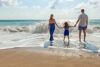 family on the beach to represent summer vacation.