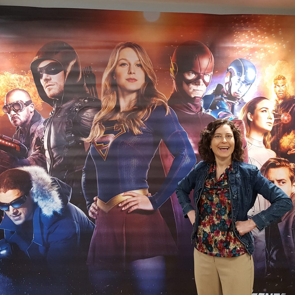 Personal brand image of Joan Koehne as Wonder Writer in front of a Super Girl poster 